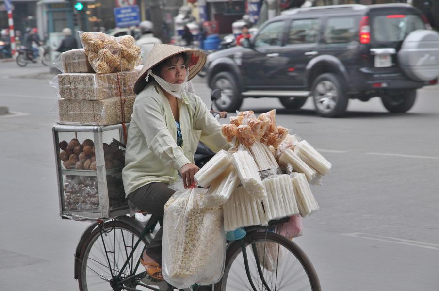 Auf überladenen Rädern balancieren vor allem Frauen Essbares und Waren des täglichen Bedarfs. 
