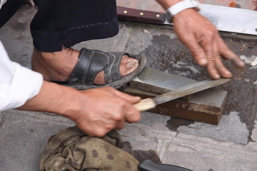 Messerschleifer gehören zu jener Handwerkergilde, die mit wenig materiellem Einsatz ein paar Dong am Tag verdienen. Dieser Mann arbeitet im wahrsten Sinne des Wortes mit Händen und Füßen. 