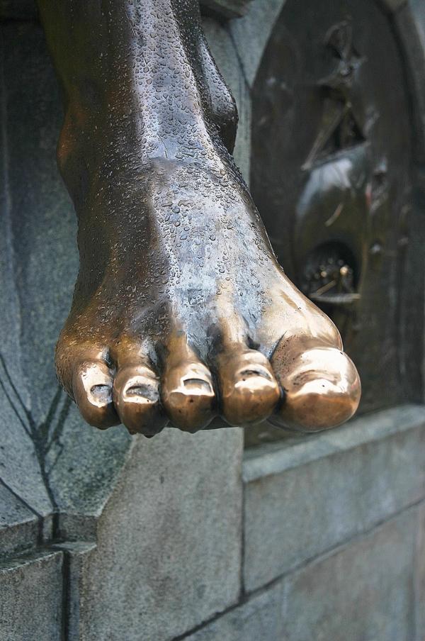 Dieser Fuß am Denkmal wird von vielen Menschen berührt, von daher der Glanz.