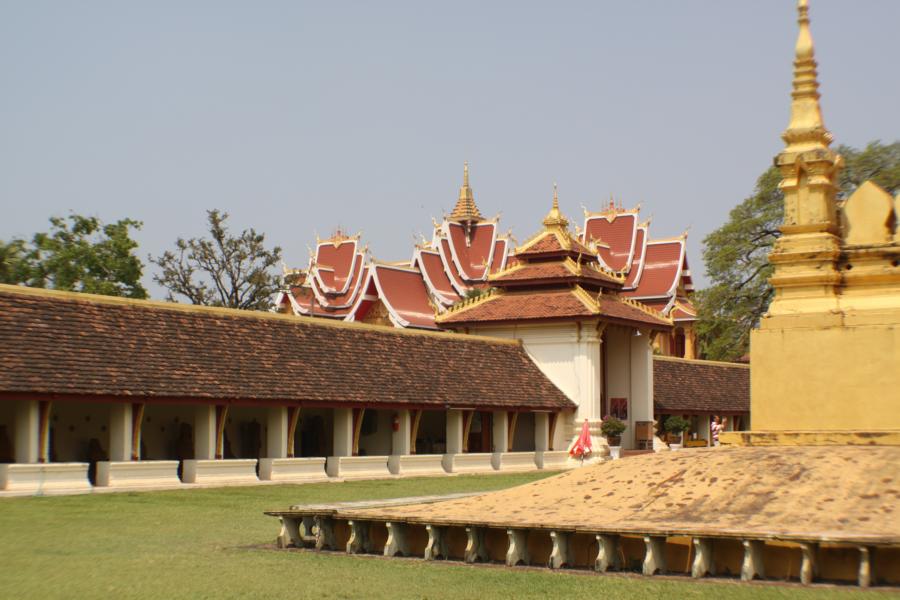 Das Monument ist von einem quadratischen, nach innen offenen, überdachten Wandelgang umgeben, in dem einige Statuen im Khmer- und im Laostil aufgestellt sind.