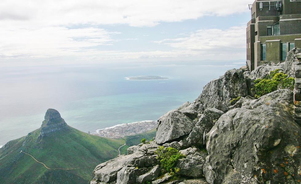 Der Tafelberg prägt die Silhouette Kapstadts. Der höchste Punkt des Tafelberges ist Maclear?s Beacon (Maclears Signalfeuer) am nordöstlichen Ende des Felsplateaus mit 1087 m. Der Tafelberg umfasst eine Gesamtfläche von rund 6500 Hektar. Robben Island ist gut zu sehen.