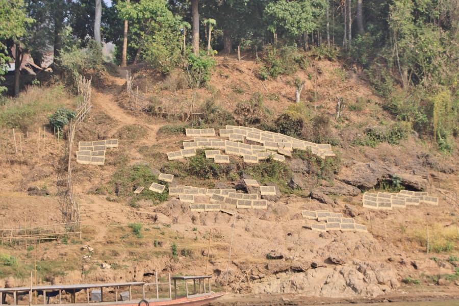 Das sonnige Ufer des Mekong nutzen einige Dorfbewohner, um Gegenstände zu trocknen. 