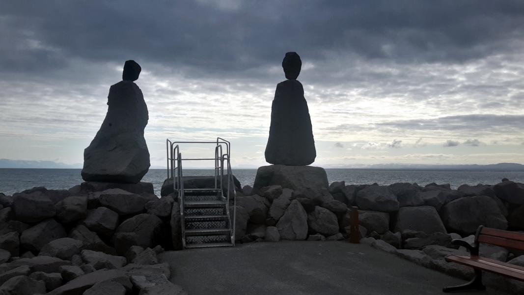 Menschliche Figuren aus Stein an der Küste von Keflavik.