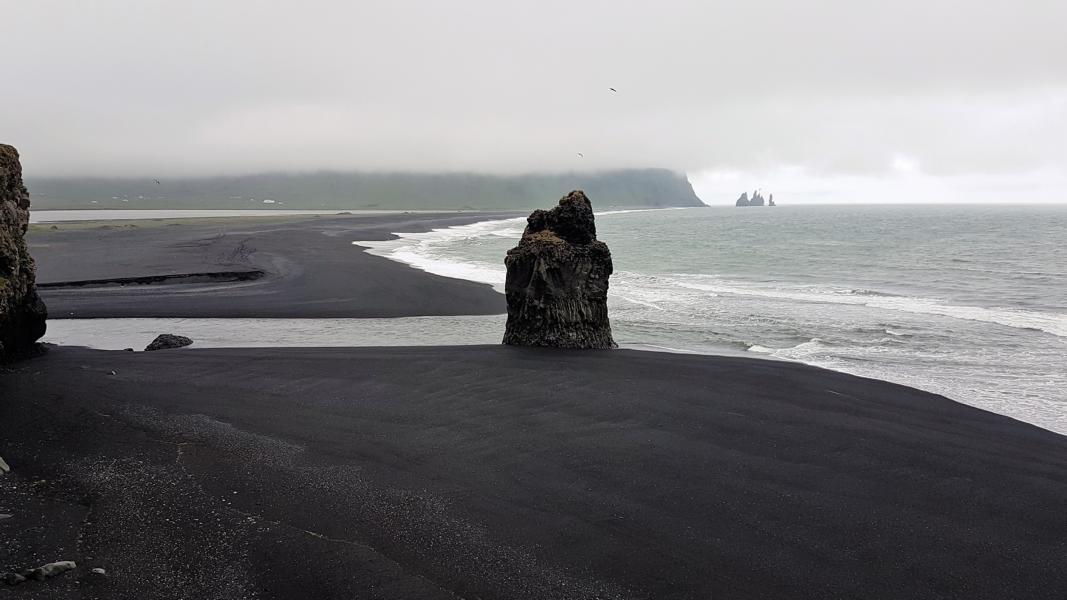 Blick von der Halbinsel Dyrhólaey auf den schwarzen Strand von Vik.