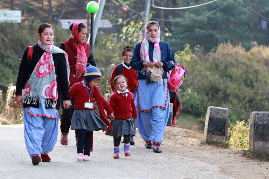 Mütter mit ihren Kindern auf dem Weg vom Dorf zur Bushaltestelle.